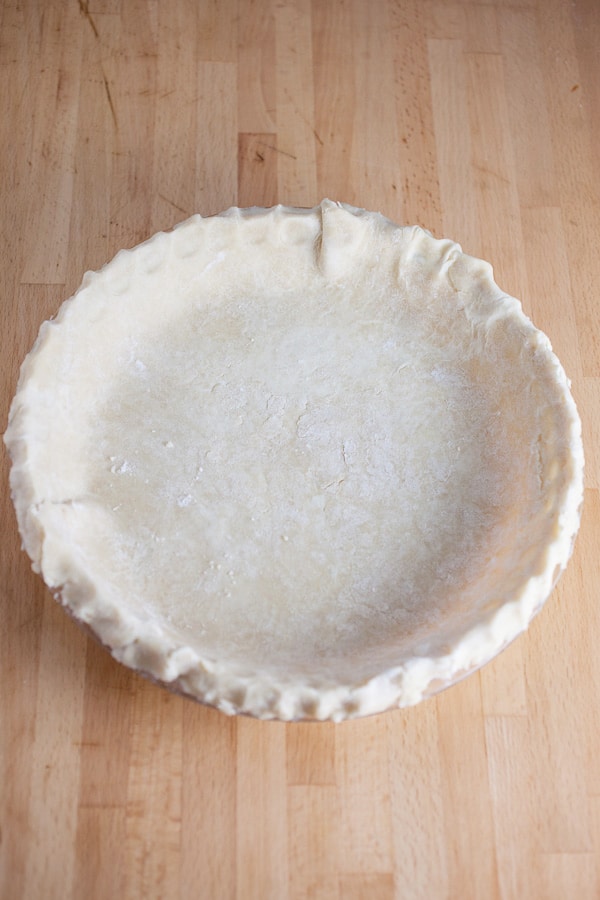 Trimmed unbaked pie dough in pie pan.