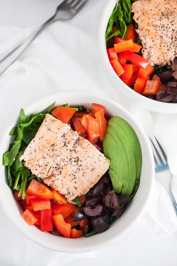 These Mediterranean Salmon and Farro Buddha Bowls are quick, easy, and healthy! Salmon is simple and fast to cook on the stove top. This fresh bowl has farro and vegetables like kalamata olives, red peppers, tomatoes, and avocados. This salad bowl makes a great lunch or dinner recipe. I love recipes like this that only take 20 minutes! #mediterranean #salmon #farro #bowl #salad #kalamataolives Mediterranean Salmon and Farro Buddha Bowl