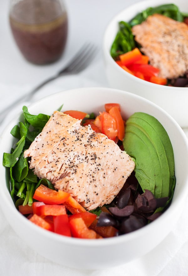 These Mediterranean Salmon and Farro Buddha Bowls are quick, easy, and healthy! Salmon is simple and fast to cook on the stove top. This fresh bowl has farro and vegetables like kalamata olives, red peppers, tomatoes, and avocados. This salad bowl makes a great lunch or dinner recipe. I love recipes like this that only take 20 minutes! #mediterranean #salmon #farro #bowl #salad #kalamataolives Mediterranean Salmon and Farro Buhhda Bowl
