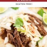 Slow cooker barbacoa tacos with chipotle coleslaw on corn tortillas with diced onions, cilantro, and lime wedges.