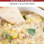 Thai potato corn chowder with slice of flatbread and Thai basil in white bowl.
