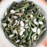 Garlic roasted green beans with almonds in ceramic bowl.