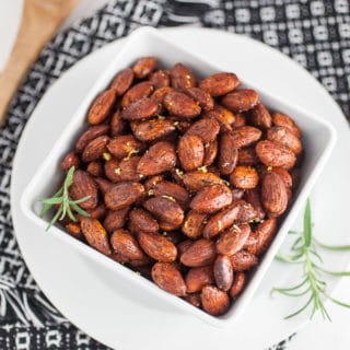 Rosemary roasted almonds in serving bowl on towel.