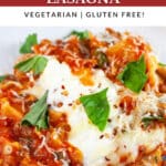 Skillet vegetable lasagna garnished with fresh basil on white plate.