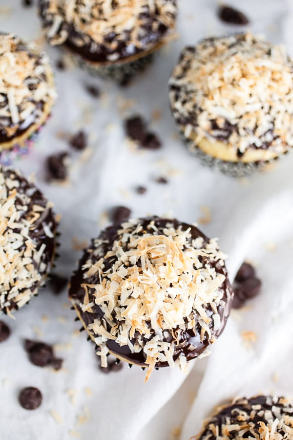 Coconut chocolate chip cupcakes with toasted coconut on white towel.