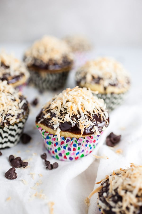 Coconut chocolate chip cupcakes with toasted cupcakes on white towel.