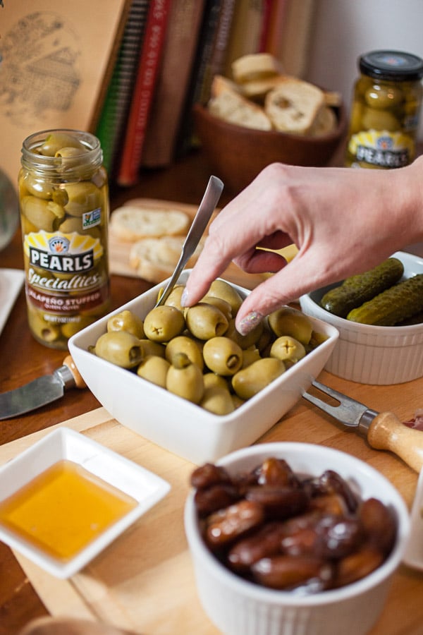 #AD This Simple Spring Antipasto Platter is so easy to assemble and is perfect for spring entertaining! The Italian antipasto platter is a recipe that's full of snacks and appetizers for a crowd. It's great for a party, holidays like Easter, weddings, bridal and baby showers, and graduations. Learn how to make a rustic antipasto platter with meat, cheese, artichokes, olives, and veggies for your next get-together. @PearlsOlives #OlivePearlsEaster #antipasto #easter #appetizer #Italian Simple Spring Antipasto Platter