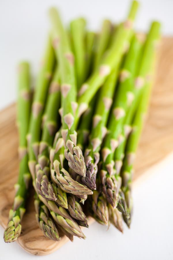 Fresh asparagus on wooden serving board.