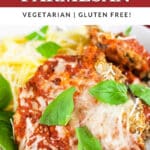 Eggplant parmesan with spaghetti noodles and fresh basil leaves in white bowl.