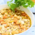 Wild rice garbanzo bean soup garnished with parsley in white bowl.