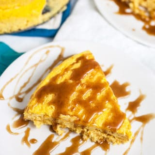 Slices of crustless pumpkin cheesecake with caramel sauce on white plates.