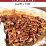 Maple bourbon pecan pie with whipped cream on white plate with fork.