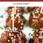 Teriyaki turkey meatballs with sesame seeds on white platter with toothpicks.