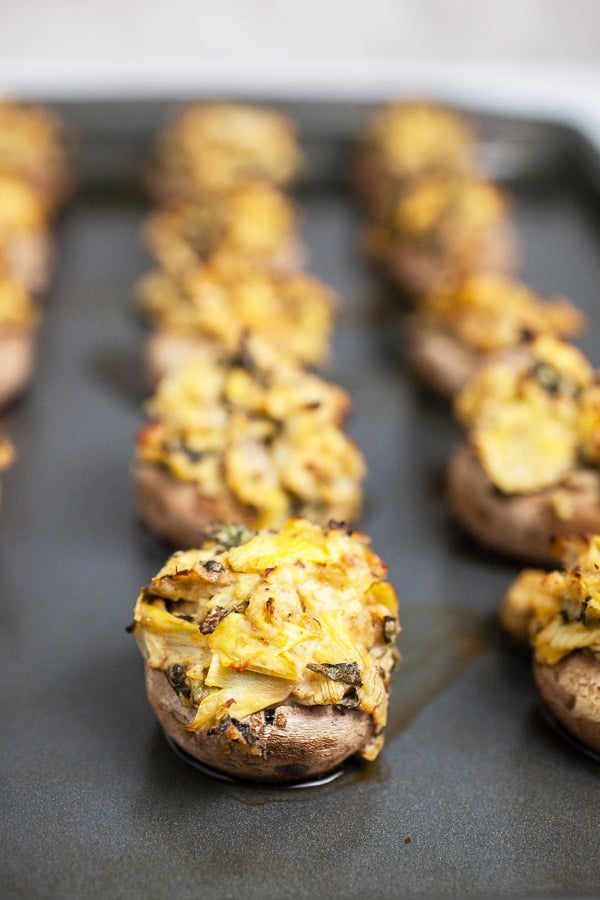 Cooked stuffed mushrooms on metal baking sheet.