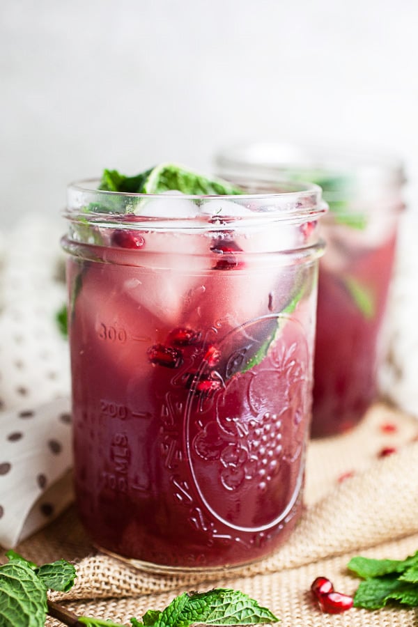 Pomegranate mojito cocktails in mason jars with fresh mint.