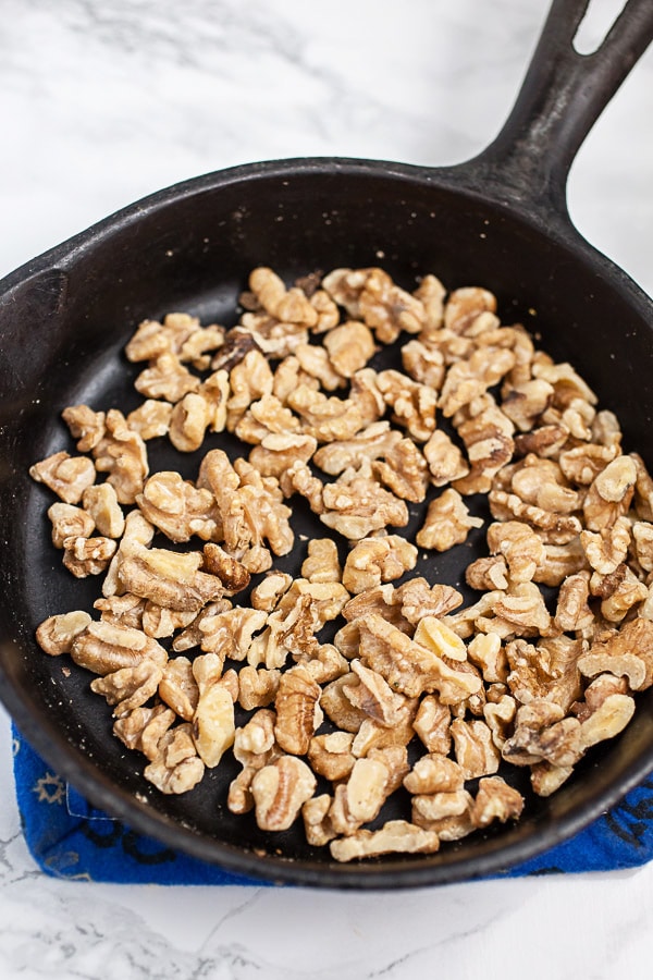 Walnuts toasted in small cast iron skillet.