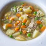 Potatoes, Peas, and Shredded Chicken In Broth In White Bowl