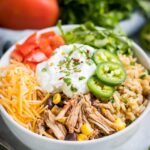 Shredded Chicken, Rice, Black Beans, Corn, Shredded Cheese, and Tomatoes In White Bowl