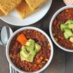 Lentil Sweet Potato Chili Topped With Avocado In Small White Bowls