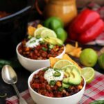 Slow Cooker Vegan Chili with Avocado and Lime In White Bowls