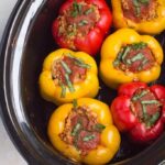 Yellow and Red Stuffed Peppers In Black Slow Cooker