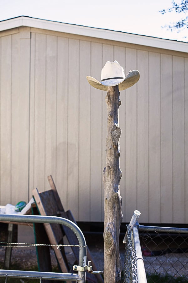 White cowboy hat on top of wood in front of building.