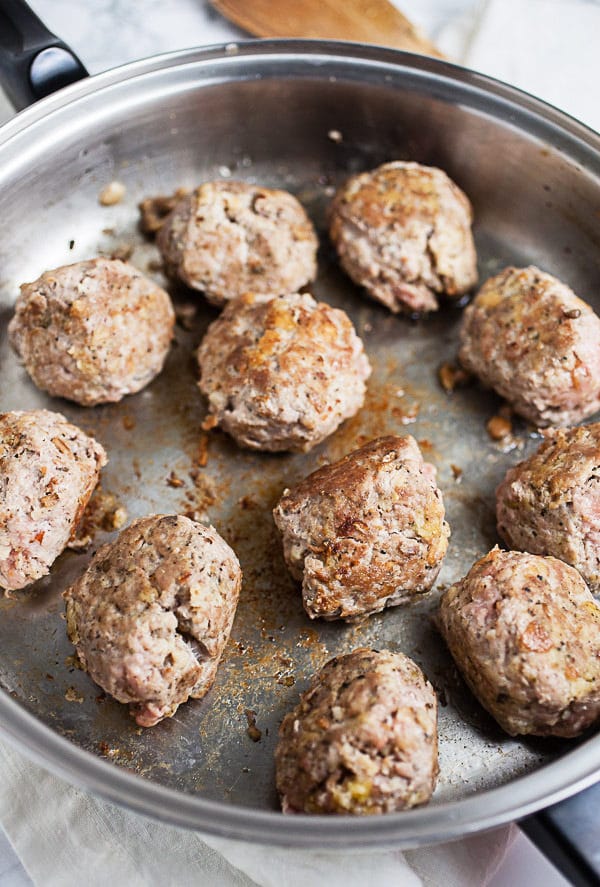 Ground turkey meatballs seared in skillet.