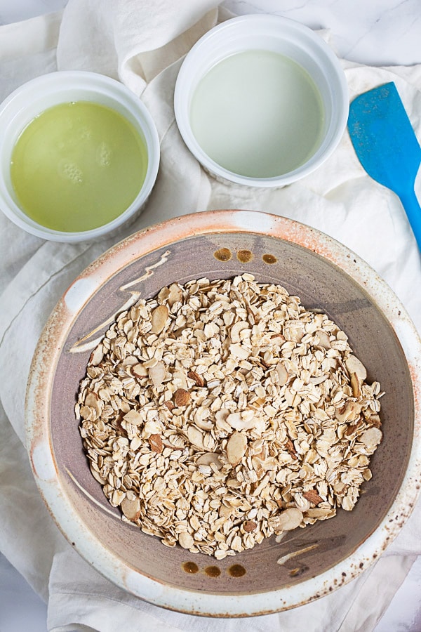 #ad These Greek Yogurt Oatmeal Cups are the perfect easy and healthy breakfast recipe! The oats are mixed with coconut oil, lemon zest, and cinnamon and then baked until crispy. They're filled with yogurt that's creamy and lightly sweetened with honey. Great for a brunch, dessert, or to serve at a party! @GreekGodsYogurt #oatmeal #yogurt #cups #healthy #glutenfree Oats and almonds, egg whites, and melted coconut oil in three separate bowls.