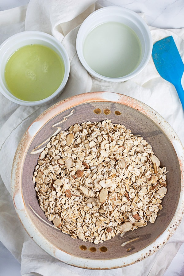 Oats and almonds, egg whites, and melted coconut oil in three separate bowls.