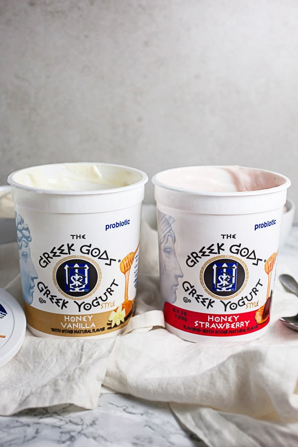 #ad These Greek Yogurt Oatmeal Cups are the perfect easy and healthy breakfast recipe! The oats are mixed with coconut oil, lemon zest, and cinnamon and then baked until crispy. They're filled with yogurt that's creamy and lightly sweetened with honey. Great for a brunch, dessert, or to serve at a party! @GreekGodsYogurt #oatmeal #yogurt #cups #healthy #glutenfree Two opened tubs of Greek Gods Greek yogurt on white towels.