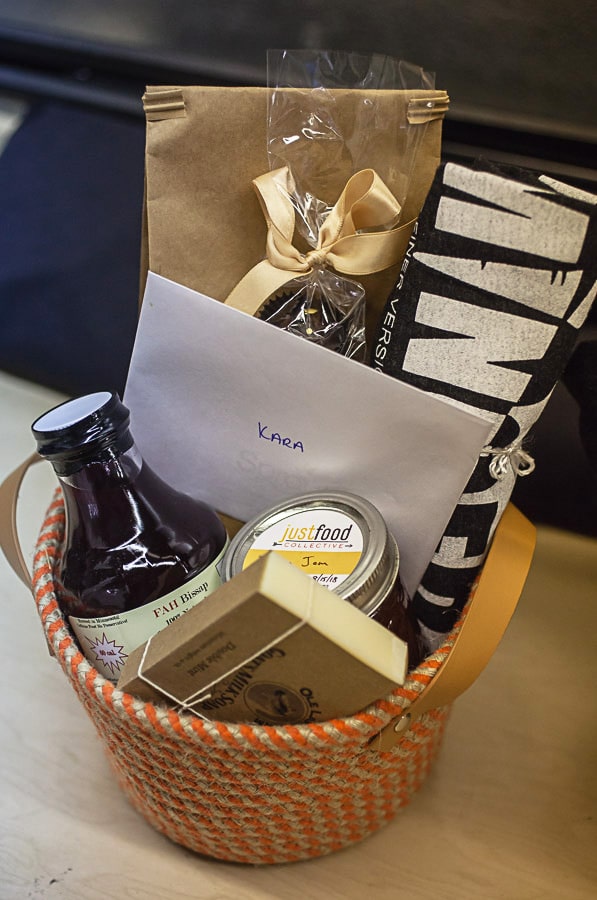 Gift basket with local ingredients sitting on table.