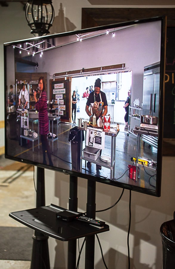 Man cooking on TV monitor.