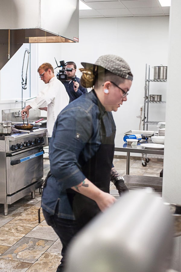 Chefs cooking in commercial kitchen.