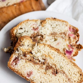 Slices of rhubarb bread with streusel on small white plate.