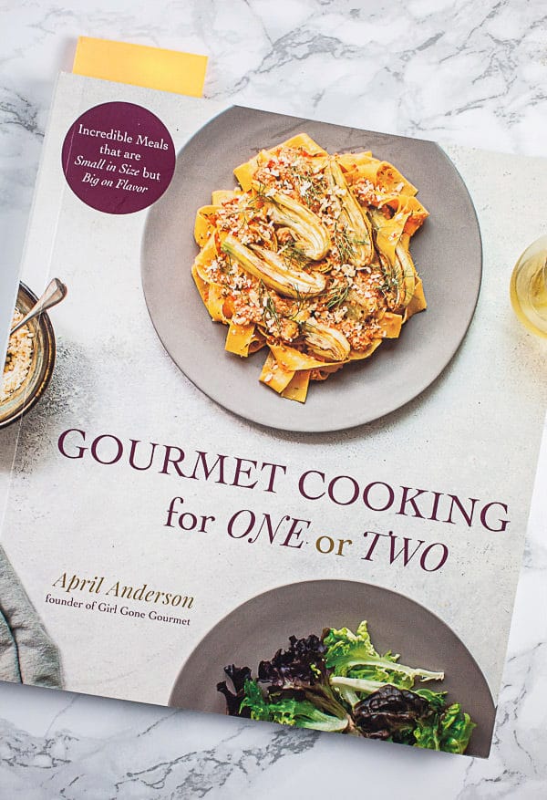 Gourmet Cooking For One or Two cookbook on white surface.