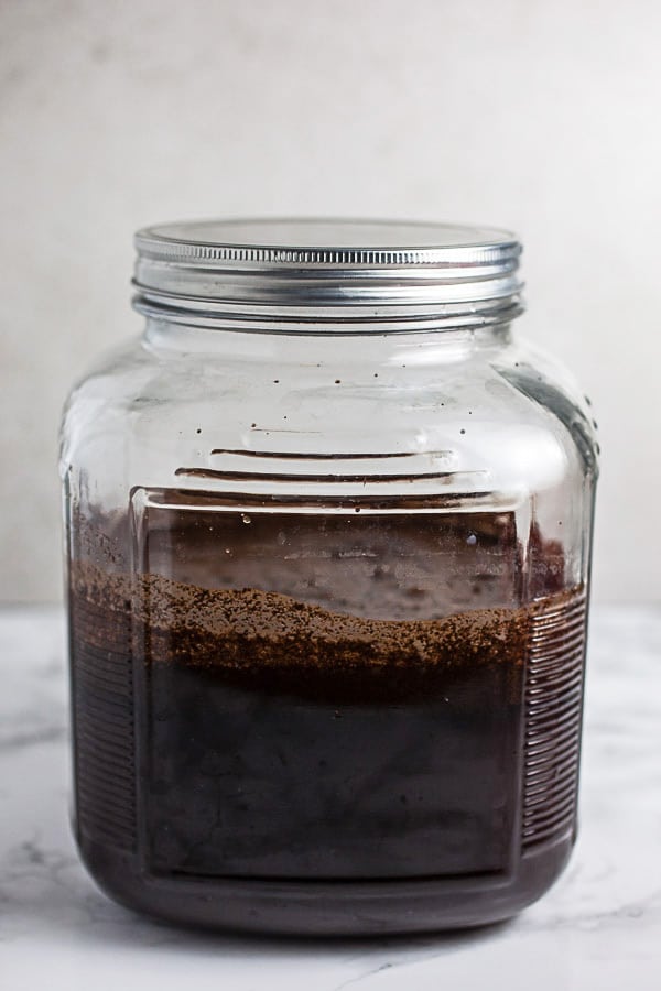Cold brew concentrate in glass container with lid.