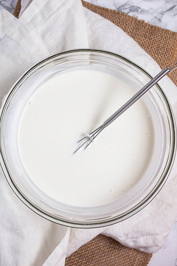 Sour cream, buttermilk, and mayo combined in small glass bowl.