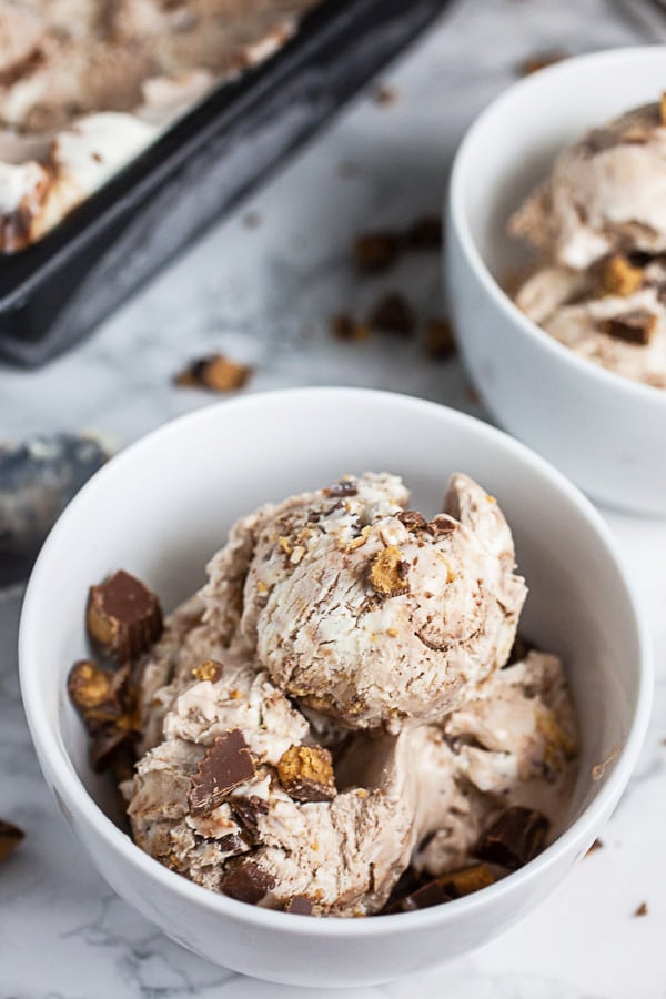 Peanut butter cup ice cream in small white bowls garnished with Reese's Peanut Butter Cups.