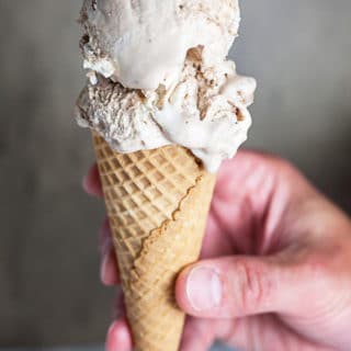 Hand holding peanut butter cup ice cream cone.