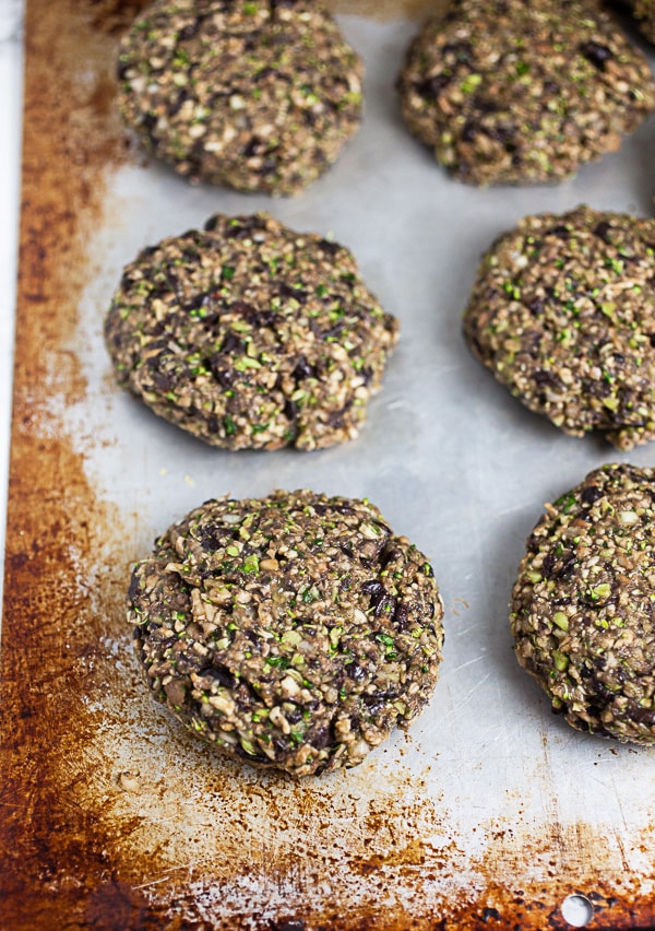 Uncooked veggie burger patties on metal baking sheet.