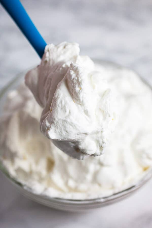 Homemade whipped cream in large glass bowl.