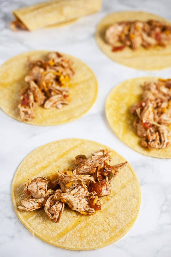 Shredded chicken mixture on corn tortillas.