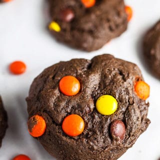 Stack of Reese's Pieces chocolate cookies on white surface.