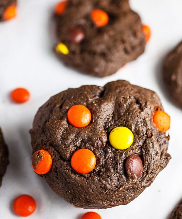 Stack of Reese's Pieces chocolate cookies on white surface.