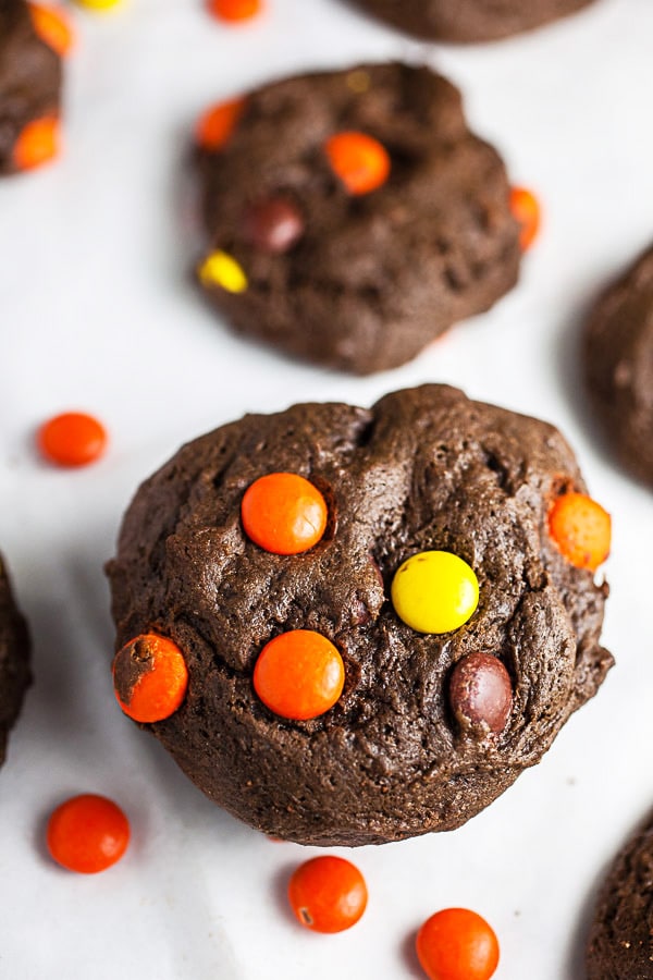 Stack of Reese's Pieces chocolate cookies on white surface.