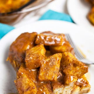 Pumpkin bread pudding with caramel sauce on small white plates.