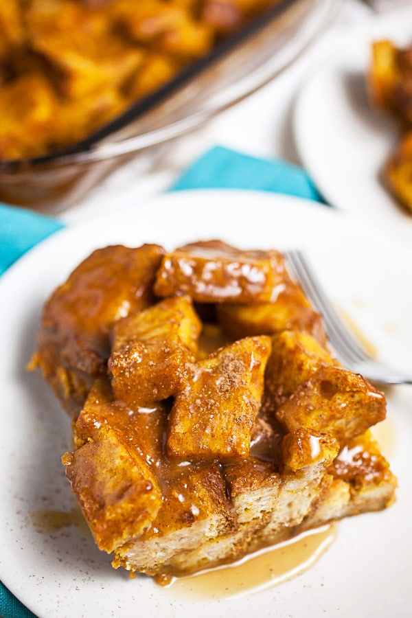 Pumpkin bread pudding with caramel sauce on small white plates.