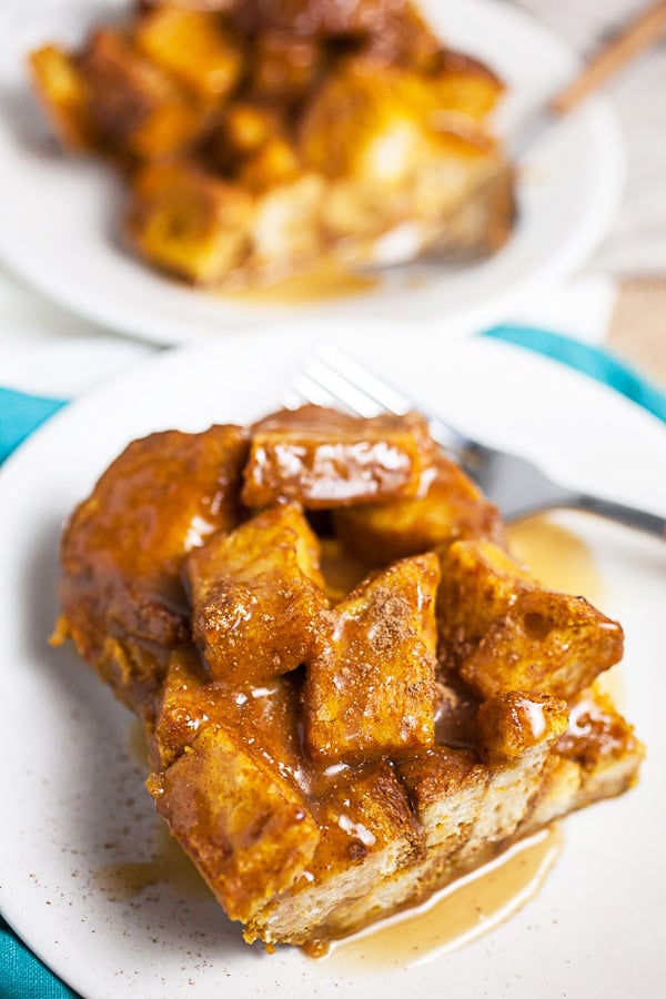 Pumpkin bread pudding with caramel sauce on small white plates.