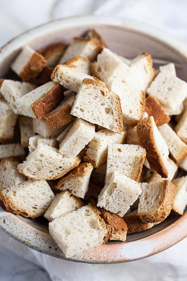 Gluten free bread cubes in ceramic bowl.