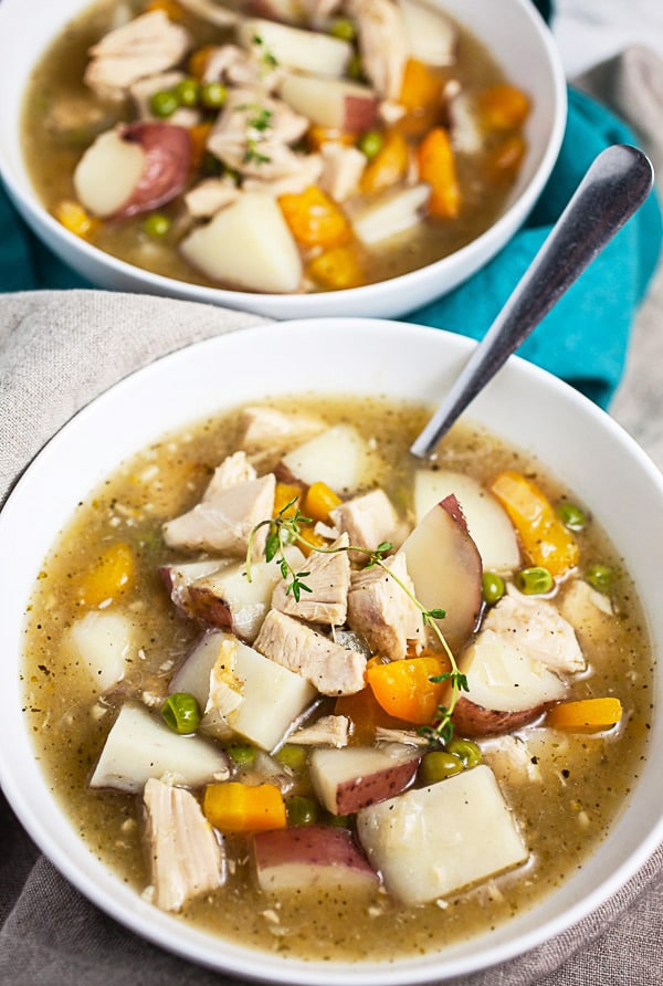 Turkey stew in white bowl with spoon.